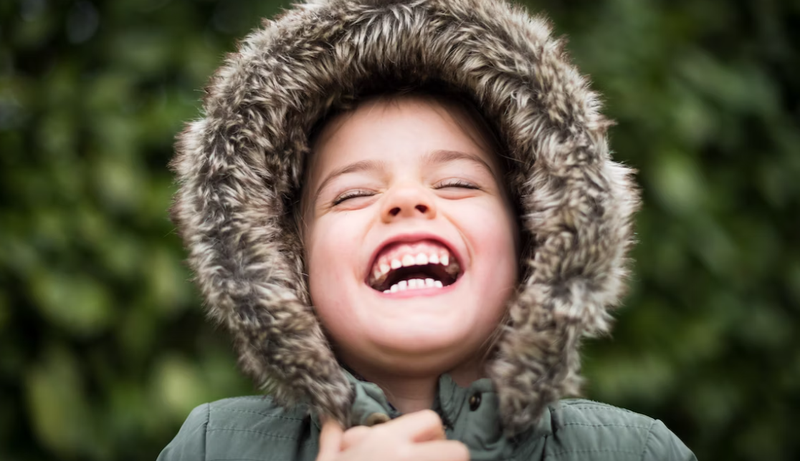 Criança com casaco sorrindo